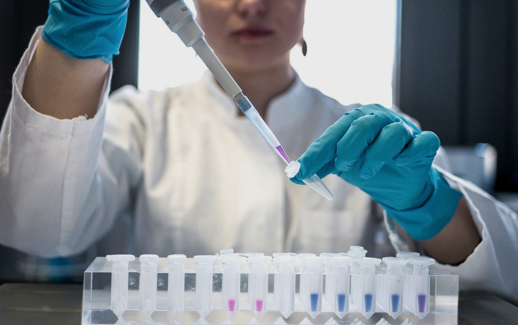 A scientist using a pipette in a laboratory